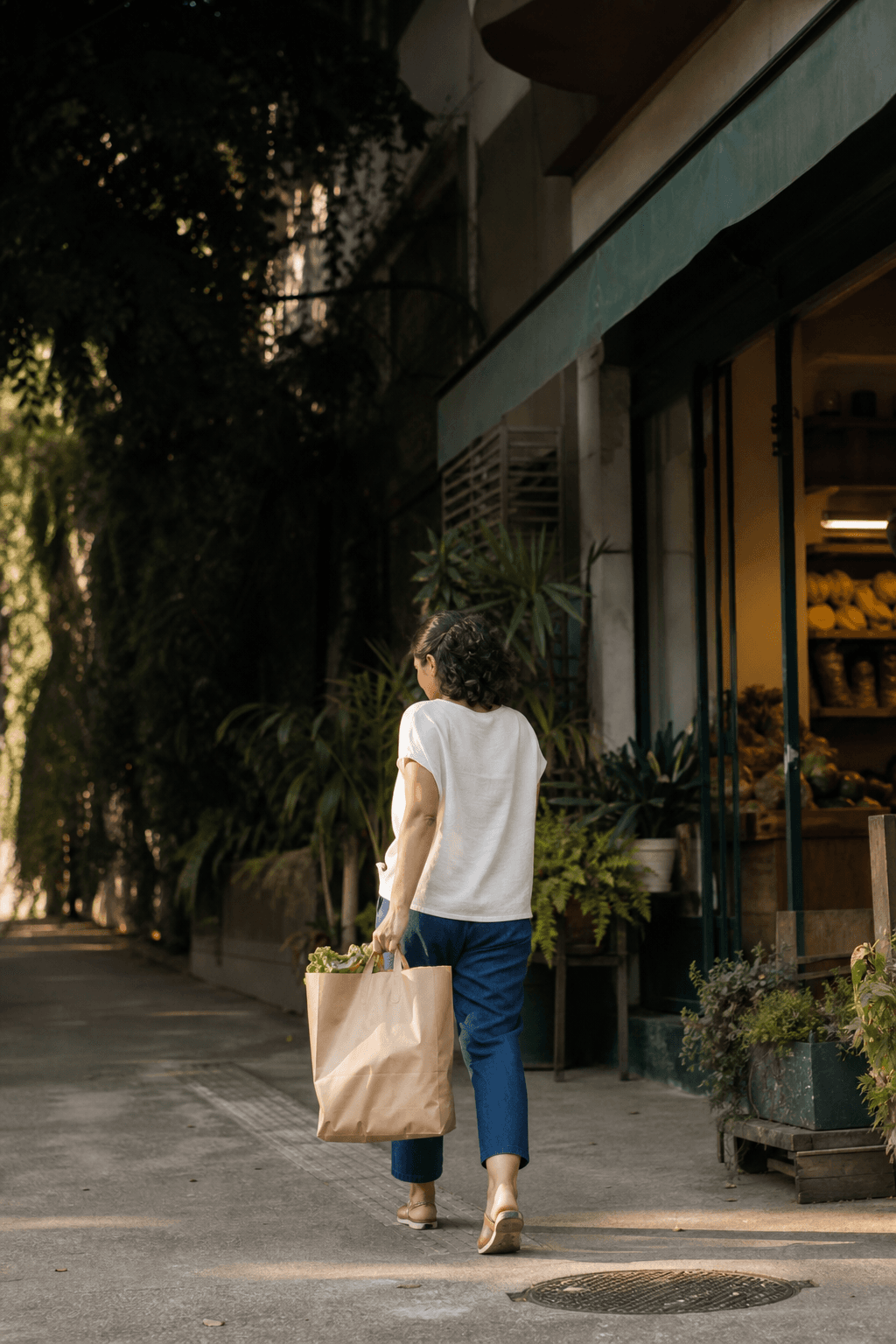 Cliente saindo de um comércio de bairro com uma sacola de compras